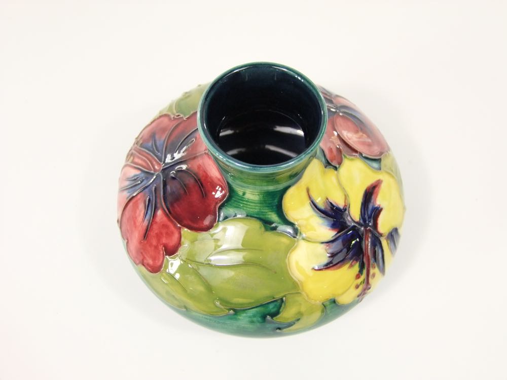 A Moorcroft vase of squat form with drawn neck and with raised and painted hibiscus decoration in