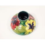 A Moorcroft vase of squat form with drawn neck and with raised and painted hibiscus decoration in
