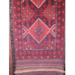 Meshwari runner decorated with red medallions in relief upon a blue ground, 62 x 157cm