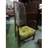 A 1920s/30s stained beechwood frame fireside chair with open arms and cane panelled back (AF)