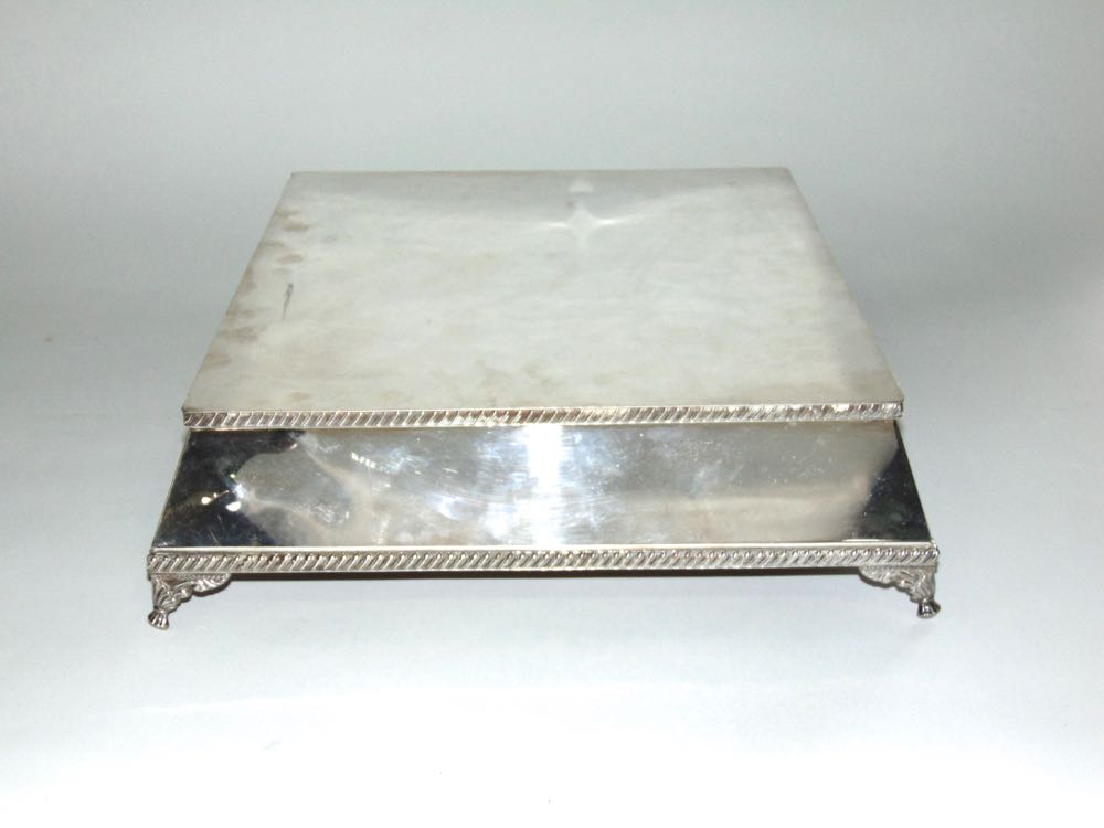 Silver plated square plinth type stand with gadrooned rim and cast scrolled feet, 13cm x 38cm wide