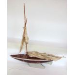 A vintage wooden pond yacht with mast and sail