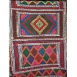 Suzmi Kelim runner decorated with vibrant diamond medallions upon a dark ground, 174 x 66cm