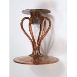 Am Arts & Crafts hand wrought copper candlestick raised on six shaped supports on a domed base, 12