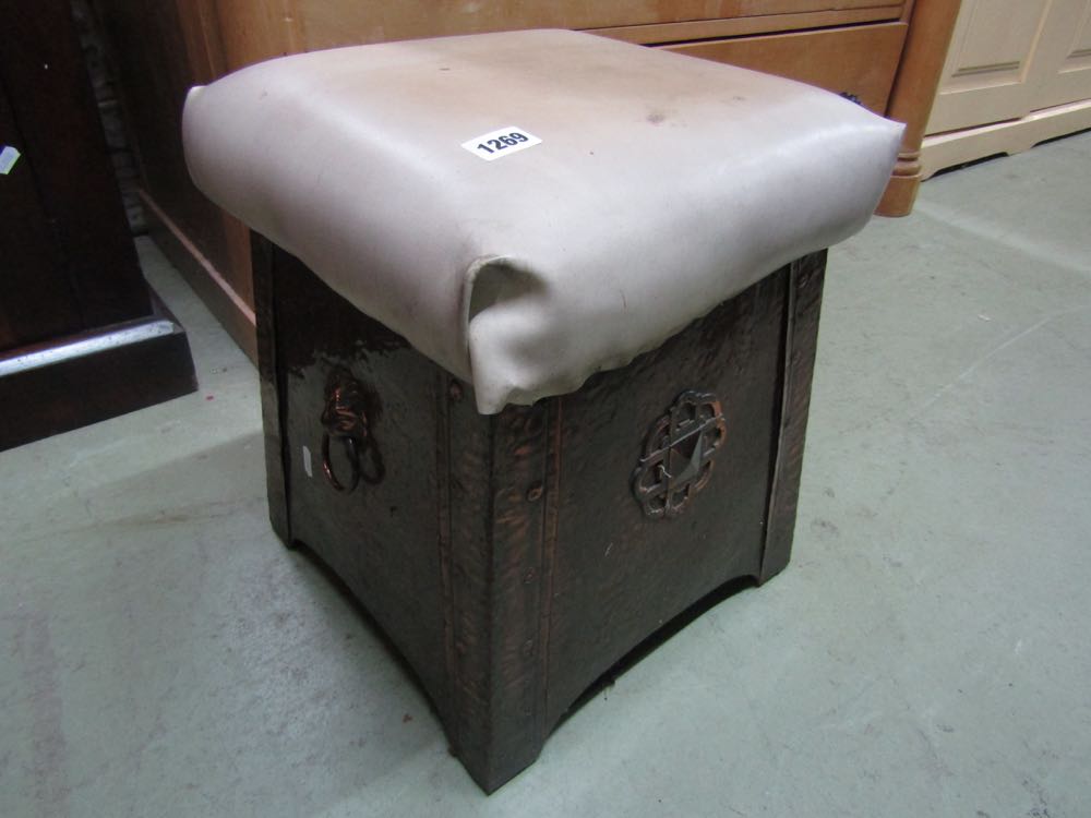 An arts and crafts hammered coal box of square tapering form with rivet panels with rising lid and