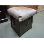 An arts and crafts hammered coal box of square tapering form with rivet panels with rising lid and