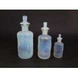 Graduated set of three Sabino glass scent bottles, each decorated in relief with art deco bathers,