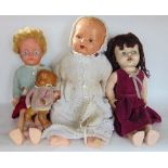 A box containing four vintage dolls.