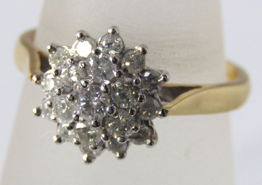 A diamond cluster ring marked 750, in white gold setting. 5.5g, size P/Q