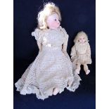 An antique bisque headed doll with fixed eyes, open mouth with top and bottom rows of teeth,