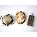 A yellow metal mother of pearl brooch together with a silver ingot pendant and a cameo brooch