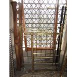 A late Victorian brass single bedstead with vertical turned rails, beneath a square arched rail with