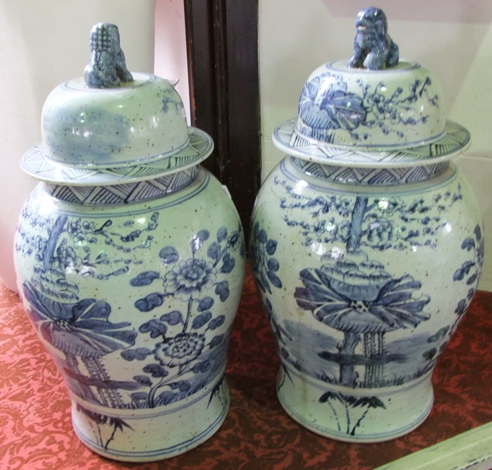 A pair of substantial oriental blue and white vases and covers with painted flowering tree and