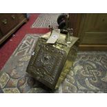 A late Victorian brass coal scuttle with decorative handle and embossed lid with classical urn and