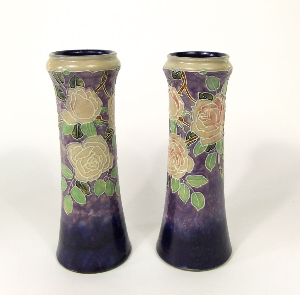 A pair of tall Royal Doulton vases of tapering form with moulded and painted rose and leaf