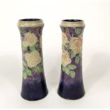 A pair of tall Royal Doulton vases of tapering form with moulded and painted rose and leaf