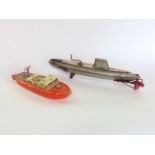 A Japanese tin plate wind-up toy of a submarine inscribed 'Nautilus' together with a further tin