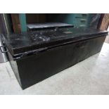 A vintage tin trunk of rectangular form with side carrying handles and applied brass plaque to