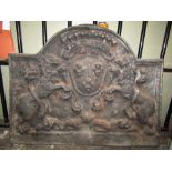 A small but heavy old English style cast iron fire back of stepped arched form with raised rampant