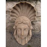 A well detailed carved wooden architectural corbel in the form of a female face mask with flowing