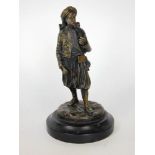 A cast bronze figure of a English looking gentleman in subcontinent type dress upon a stepped