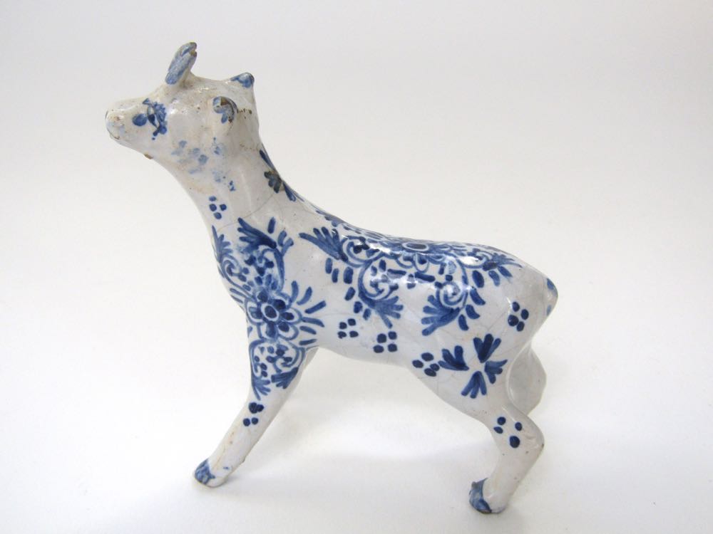 A small 19th century Delft model of a goat-like animal with blue and white painted floral decoration