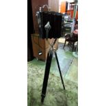 A contemporary floor standing chrome floor lamp, on a telescopic black tripod stand