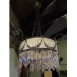 An antique hanging boudoir lamp fitted with four scrolled branches centrally fitted with a centre