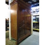 A contemporary cherry wood side cupboard enclosed by a pair of arched moulded panelled doors, the