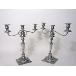 A pair of classical style silver plated twin branch candelabra with scrolled brackets and baluster
