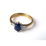 An 18ct gold ring with oval sapphire flanked by baguette cut diamonds, size J, 3g