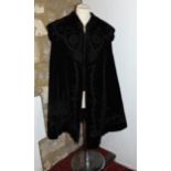 Ladies black velvet cape with applied decoration to edges and collar and quilted lining, together