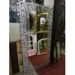 A large contemporary wall mirror of rectangular form with bevelled edge plate within a decorative