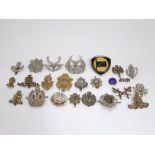 A collection of British Military cap and regimental badges, etc