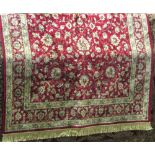 A Kashmir red ground rug with floral detail within running borders, 240x150cm