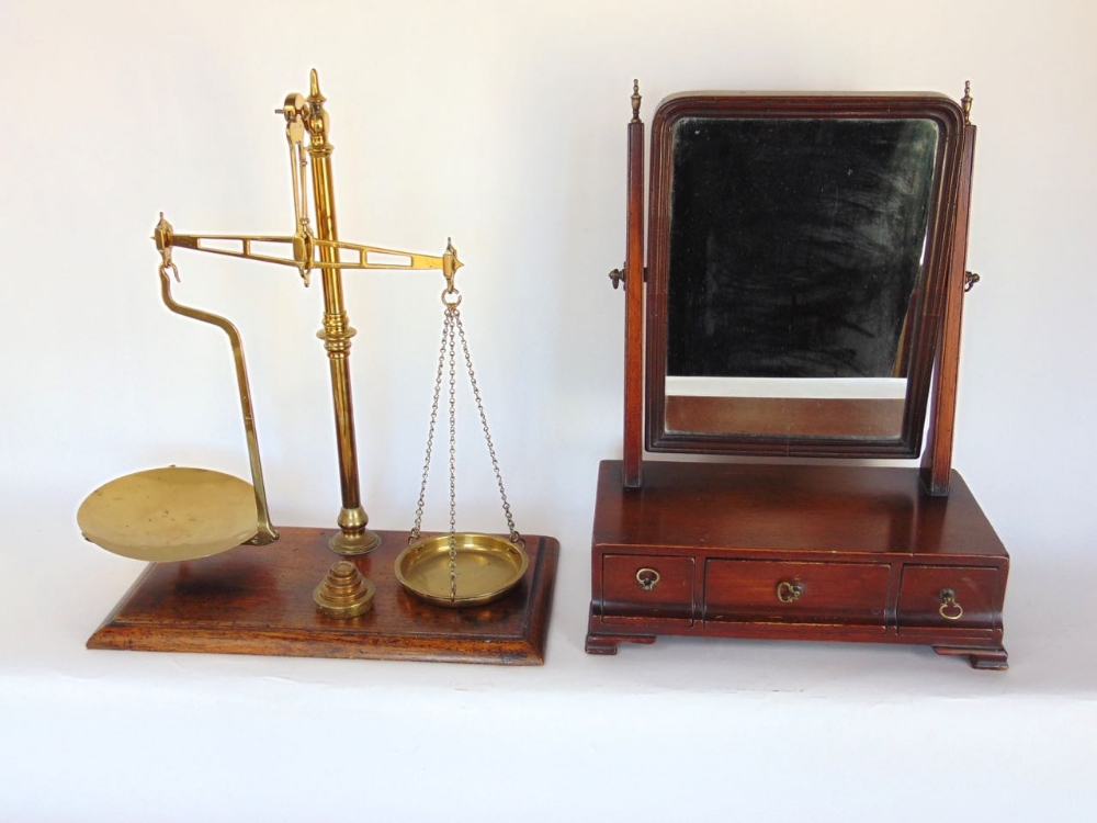 A Georgian mahogany swing mirror upon a base fitted with three cushion drawers together with a