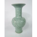 An oriental vase with celadon glaze, globular body and flared drawn neck and with relief moulded