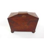 A Regency flame mahogany sarcophagus tea caddy with ring handles and hinged lid enclosing a fitted