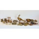 A collection of brassware to include a cast brass fly, peacock, paw feet, horse brasses, etc.