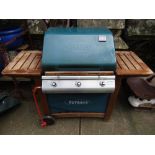 An Outback Frontier III gas barbecue with teak wood frame and all weather cover