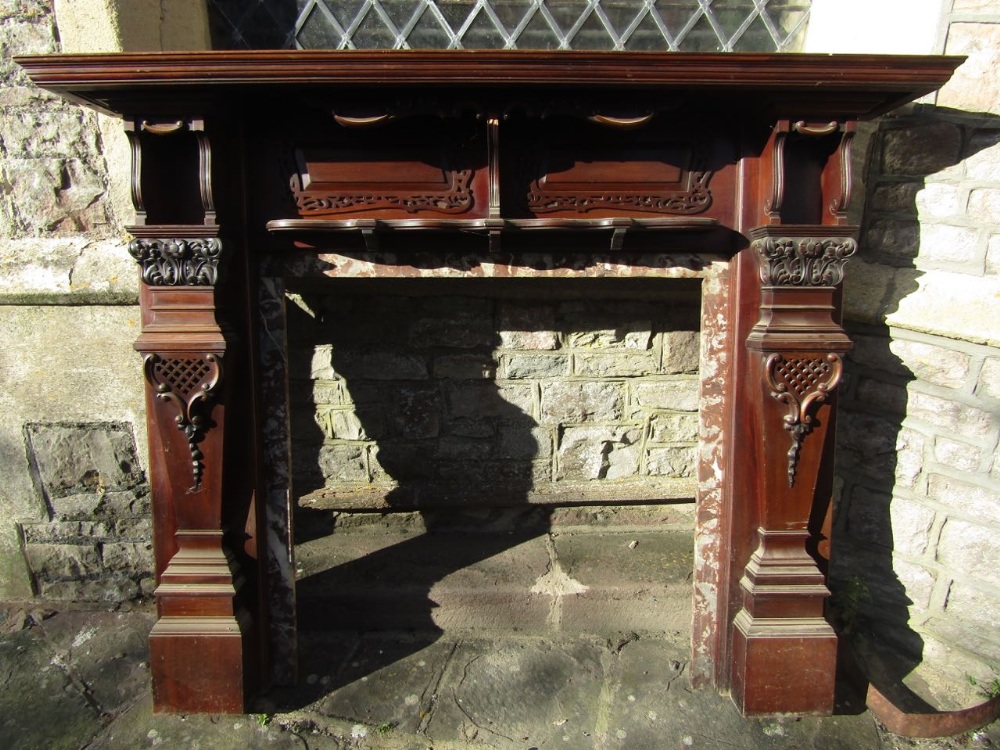 A substantial Edwardian mahogany and marble lined fire surround with carved and pierced detail,