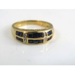 An 18ct sapphire and diamond ring with two rows of square cut sapphires separated into three