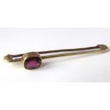 A 14ct gold tie pin set with a garnet, 3.5g