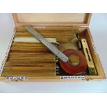 A box containing a large collection of articulated rulers and measuring tools together with spirit