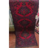 A Turkish style wool runner with bright red field, multi medallion centre, set within running