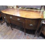 A Regency mahogany sideboard with shaped outline fitted with an arrangement of drawers and cupboards