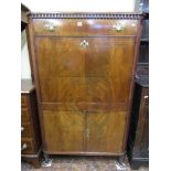 A 19th century mahogany veneered secretaire abbatant, the front elevation with dentil frieze and