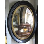 A pair of 19th century style oval wall mirrors in moulded frames and with gilded slips enclosing