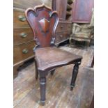 A Victorian mahogany hall chair, the shield shaped back with moulded outline over a solid seat