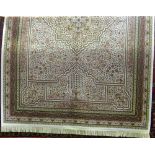 An ivory ground silk rug with central medallion and miniature floral detail throughout within